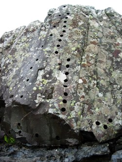 A Palaeogene cone-sheet at Mingary Pier, Ardnamurchan, defaced by core sampling. Originally featured on the cover of this magazine in January 2010, the line of smaller holes to the left was drilled around 30-40 years ago.